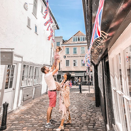 Influencer Carolina Fryer and her husband and daughter on a cobblestone street